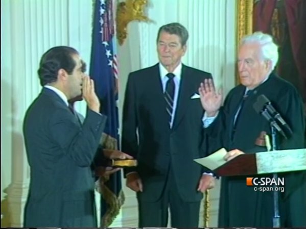 Antonin Scalia (left) being sworn into the Supreme Court as former president Ronald Reagan (center) watches