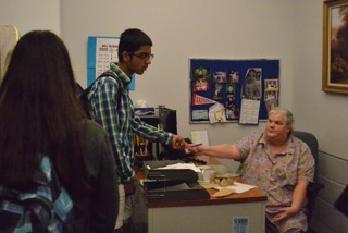 Connie Campana (right) checking students in at the attendance office.