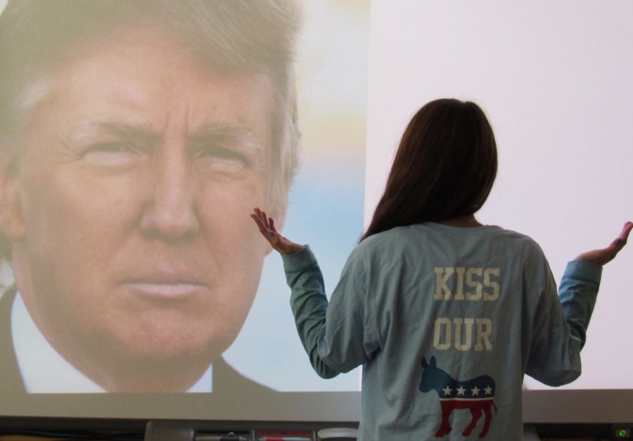 A Yorktown Young Democrats member stands in front of a picture of Republican Presidential Candidate, Donald Trump
