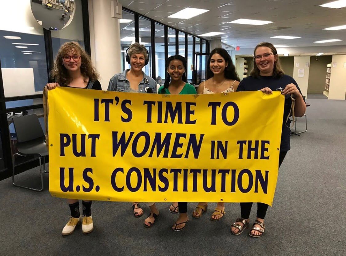 Students and activists pose with a banner to spread their message.